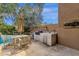 Outdoor kitchen and dining area with built-in barbecue, marble countertop, and seating for four, perfect for entertaining at 7740 E Gainey Ranch Rd # 36, Scottsdale, AZ 85258