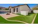 The backyard showcases a fire pit, lush artificial turf, and sleek brick pavers, perfect for outdoor enjoyment at 9001 S 18Th Way, Phoenix, AZ 85042