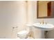 Half bathroom with a pedestal sink, decorative mirror, and toilet at 9001 S 18Th Way, Phoenix, AZ 85042