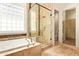 Bathroom features soaking tub, glass shower, travertine tile and separate toilet room at 9001 S 18Th Way, Phoenix, AZ 85042