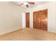 Neutral carpeted bedroom with ceiling fan, double doors, and large closet at 9001 S 18Th Way, Phoenix, AZ 85042