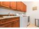 Laundry room equipped with a large sink, storage cabinets, and modern washer and dryer at 9001 S 18Th Way, Phoenix, AZ 85042
