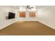 Large living room with neutral carpet, ceiling fan and a flat screen television at 9001 S 18Th Way, Phoenix, AZ 85042