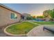 Spacious backyard with a lush lawn, a pool with water feature, and a covered patio, perfect for outdoor living at 9388 W Cashman Dr, Peoria, AZ 85383