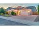 Inviting home featuring a brick driveway, two-car garage, and manicured landscaping at 9388 W Cashman Dr, Peoria, AZ 85383