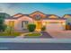 Charming home featuring a well-manicured lawn, a two-car garage, and desert landscaping at 9388 W Cashman Dr, Peoria, AZ 85383