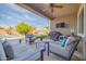 Covered patio boasts a ceiling fan, TV, and cozy seating, perfect for outdoor entertaining at 9388 W Cashman Dr, Peoria, AZ 85383