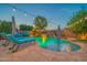 Backyard pool with waterfall feature, tanning deck, outdoor umbrellas, and inviting lounge furniture at 9388 W Cashman Dr, Peoria, AZ 85383