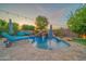 Beautiful backyard pool with a waterfall feature, surrounded by pavers, lounge chairs, and hanging lights at 9388 W Cashman Dr, Peoria, AZ 85383