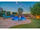 Backyard pool with a rock waterfall, tanning deck and ambient lighting for evening enjoyment at 9388 W Cashman Dr, Peoria, AZ 85383