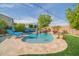 Backyard pool featuring a slide and waterfall surrounded by lush landscaping, perfect for summer fun at 9388 W Cashman Dr, Peoria, AZ 85383
