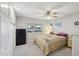 Bedroom featuring ceiling fan, window and a bed with yellow patterned bedding and a small storage unit at 10303 W Desert Forest N Cir, Sun City, AZ 85351