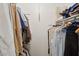 Walk in closet with shelving on both sides, full of hanging and folded clothes for storage space at 10303 W Desert Forest N Cir, Sun City, AZ 85351