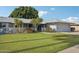 Well-maintained single-story home featuring a lush green lawn and mature landscaping at 10303 W Desert Forest N Cir, Sun City, AZ 85351