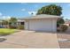 Attached two-car garage with an expansive driveway and desert landscaping at 10303 W Desert Forest N Cir, Sun City, AZ 85351