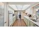 Galley kitchen featuring all white appliances, ample counterspace, and wood-look flooring at 10303 W Desert Forest N Cir, Sun City, AZ 85351