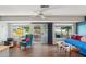Bright living area featuring vinyl floors, ample windows, and a sliding glass door at 10303 W Desert Forest N Cir, Sun City, AZ 85351
