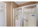 Bathroom shower unit with clear glass doors, shower head and handle with safety bar and clean products at 10303 W Desert Forest N Cir, Sun City, AZ 85351