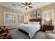 A primary bedroom features three windows with shutters, ceiling fan and dark wood accents at 12715 W Crestvale Dr, Peoria, AZ 85383