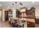 A kitchen features pendant lights above a granite countertop island with wooden cabinets and stainless steel appliances at 12715 W Crestvale Dr, Peoria, AZ 85383