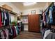 A walk-in closet provides ample storage space with wood flooring and lots of hanging storage at 12715 W Crestvale Dr, Peoria, AZ 85383