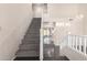 Bright entryway featuring a carpeted staircase and sleek, dark tile flooring that leads into the home at 13408 W Mauna Loa Ln, Surprise, AZ 85379