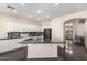 Open kitchen with center island, modern appliances, and white cabinets at 13408 W Mauna Loa Ln, Surprise, AZ 85379