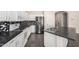 Well-lit kitchen with stainless steel appliances, black countertops, and white cabinets at 13408 W Mauna Loa Ln, Surprise, AZ 85379
