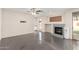 Cozy living room featuring a brick fireplace, ceiling fan, and tile flooring at 13408 W Mauna Loa Ln, Surprise, AZ 85379