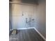 Bright laundry room with brick walls, gray flooring, and white shelving ready for organizing cleaning supplies at 13839 N 33Rd St, Phoenix, AZ 85032