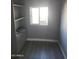 Spare room with a closet with shelves, large window, and gray walls and flooring ready for customization at 13839 N 33Rd St, Phoenix, AZ 85032