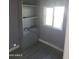 Spare room with a closet with shelves, large window, and gray walls and flooring ready for customization at 13839 N 33Rd St, Phoenix, AZ 85032