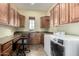 Spacious laundry room featuring tiled floors, wood cabinets, and front loading washer and dryer at 1681 E Maygrass Ln, Queen Creek, AZ 85140