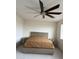 Minimalist bedroom with a neutral-toned bed frame, side tables, and a large ceiling fan at 16823 S 27Th Ave, Phoenix, AZ 85045