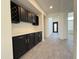 Hallway with custom cabinets, wine racks, and light tile floors at 16823 S 27Th Ave, Phoenix, AZ 85045