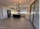 Spacious kitchen with white cabinets, dark island, modern lighting, and stainless-steel appliances at 16823 S 27Th Ave, Phoenix, AZ 85045