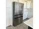 Stainless-steel refrigerator next to white kitchen cabinets and quartz countertops at 16823 S 27Th Ave, Phoenix, AZ 85045