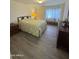 Comfortable bedroom with wood floors, floral bedding, dresser and ample light from the windows at 17404 N 99Th Ave # 136, Sun City, AZ 85373