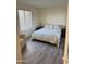 Cozy bedroom with wood floors, white walls, a plush bed and natural light from window at 17404 N 99Th Ave # 136, Sun City, AZ 85373