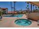 Outdoor pool and hot tub area with palm trees and lounge seating at 17404 N 99Th Ave # 136, Sun City, AZ 85373