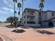 Exterior view of multi-story building with palm trees and parking at 17404 N 99Th Ave # 136, Sun City, AZ 85373