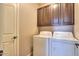 Convenient laundry room equipped with washer, dryer, and upper cabinets for storage at 18474 N Celis St, Maricopa, AZ 85138