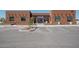 Commercial building with a brown stucco exterior, multiple windows, and designated parking spaces at 2206 S Ellsworth Rd # 157B, Mesa, AZ 85209