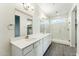 Bright bathroom with dual sinks, a large mirror, and a modern glass-enclosed shower at 24953 S 190Th Dr, Buckeye, AZ 85326