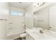Bright bathroom featuring a shower over tub, white fixtures and a large vanity mirror at 24953 S 190Th Dr, Buckeye, AZ 85326
