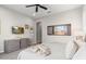 Neutral bedroom design with a large window, dresser, and ceiling fan at 26774 W Piute Ave, Buckeye, AZ 85396
