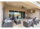 Covered patio with comfortable seating, ceiling fan, and outdoor television at 26774 W Piute Ave, Buckeye, AZ 85396
