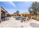 Beautiful backyard showcasing a pool, stone patio, barbecue, and lounge chairs at 26774 W Piute Ave, Buckeye, AZ 85396