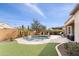 Inviting backyard with a sparkling pool, lush landscaping, and travertine patio at 26774 W Piute Ave, Buckeye, AZ 85396