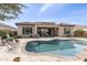 Expansive backyard featuring a pool, travertine patio, and desert landscaping at 26774 W Piute Ave, Buckeye, AZ 85396